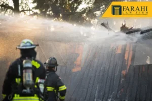 Bomberos rociando agua sobre una estructura de madera en llamas.